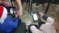 dzieci trzymające swoje odciski dłoni