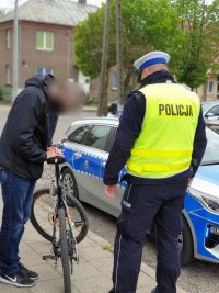 policjant kontrolujący rowerzystę i jednoślad