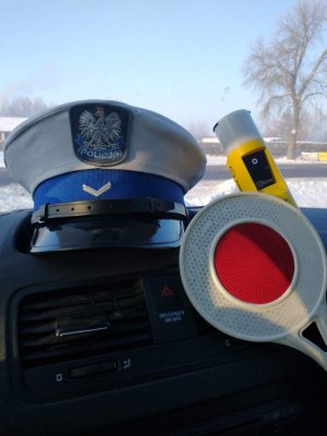 na zdjęciu czapka policyjna, urządzenie do badania stanu trzeźwości koloru żółtego oraz biało - czerwona tarcza do kierowania ruchem
