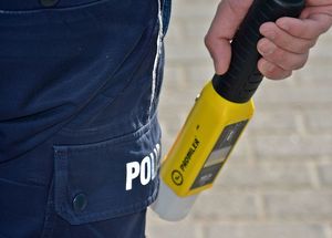 policjant trzyma w ręku urządzenie do badania stanu trzeźwości